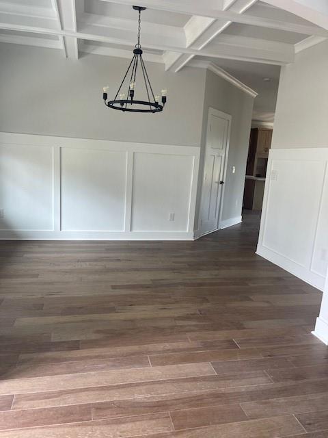 129 Silvercrest Dr, Acworth, GA 30101 - unfurnished dining area featuring a decorative wall, coffered ceiling, a chandelier, beamed ceiling, and dark wood-type flooring