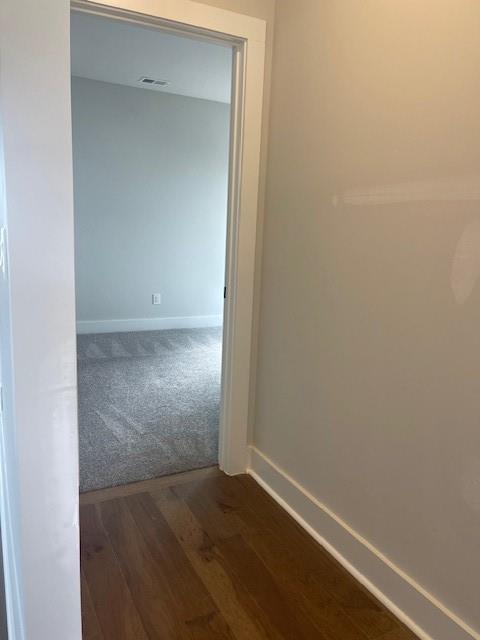 129 Silvercrest Dr, Acworth, GA 30101 - hallway with baseboards, dark colored carpet, and dark wood-type flooring
