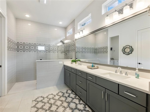 bathroom with tile patterned flooring, vanity, and tiled shower