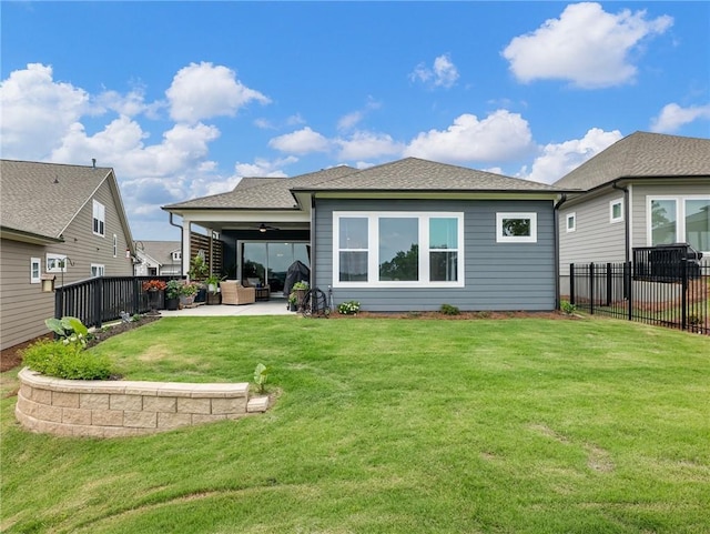 back of property with ceiling fan, a patio, and a lawn