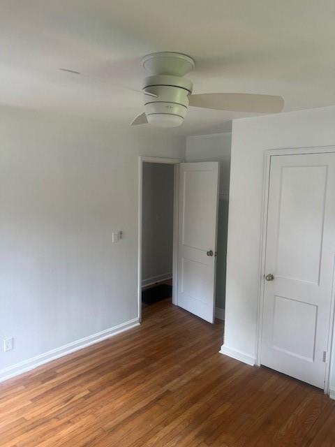 empty room with ceiling fan and hardwood / wood-style floors