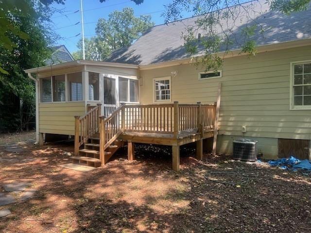 rear view of house with a wooden deck and a sunroom