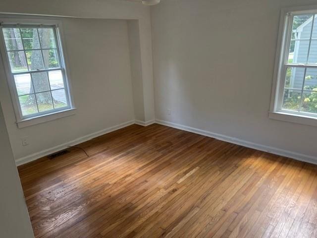 spare room with hardwood / wood-style flooring and a wealth of natural light