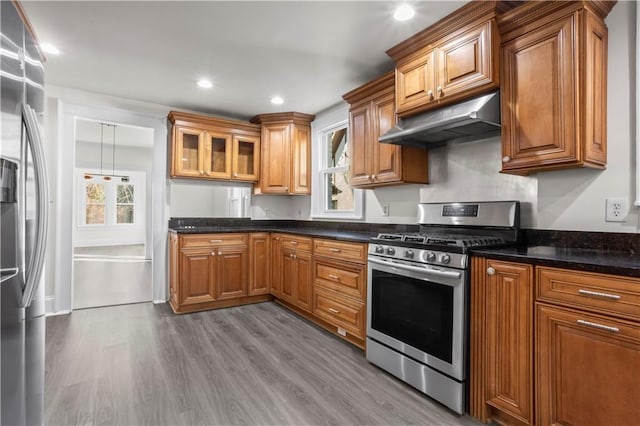 kitchen featuring appliances with stainless steel finishes, light hardwood / wood-style flooring, and dark stone counters