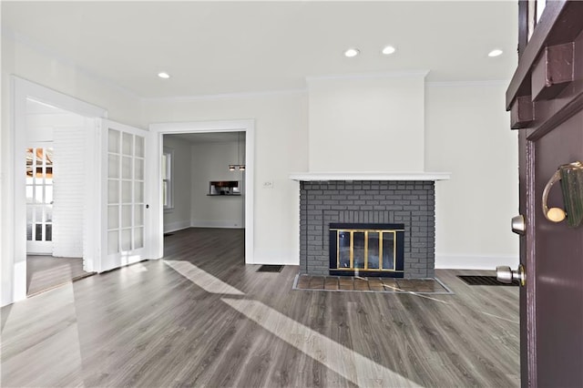 unfurnished living room featuring hardwood / wood-style flooring, ornamental molding, and a fireplace