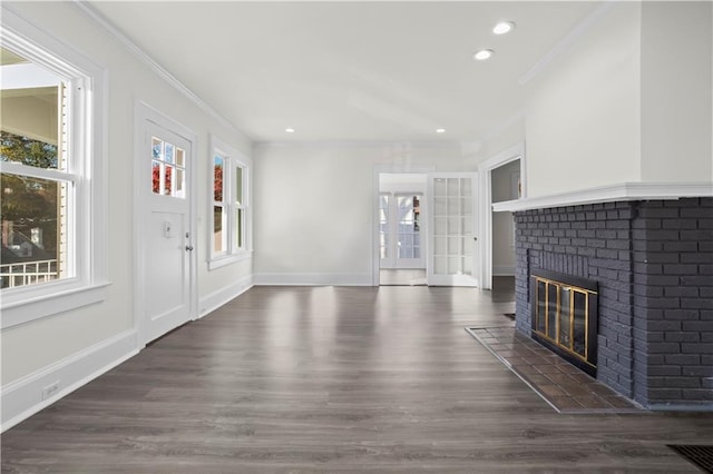 unfurnished living room featuring dark hardwood / wood-style floors, a brick fireplace, and crown molding