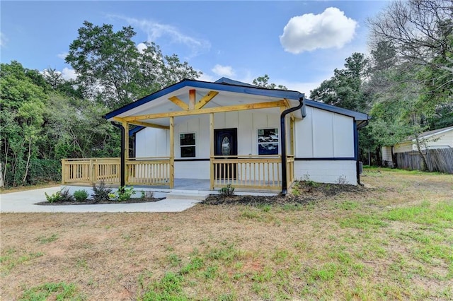 view of front facade with board and batten siding, a porch, and a front lawn