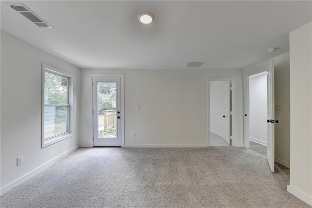 empty room featuring baseboards, carpet floors, and visible vents