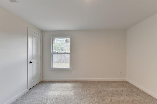 spare room featuring light carpet, baseboards, and visible vents