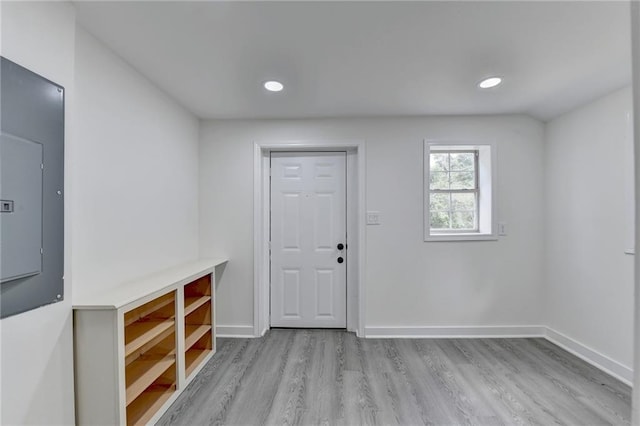 foyer entrance with baseboards, recessed lighting, wood finished floors, and electric panel