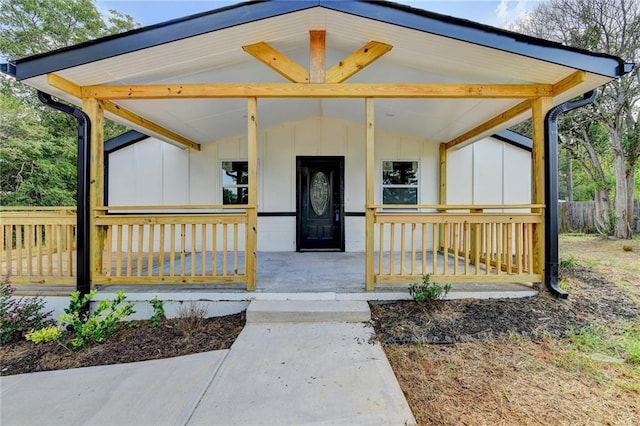 view of exterior entry with covered porch and board and batten siding