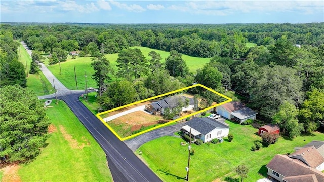 bird's eye view with a wooded view