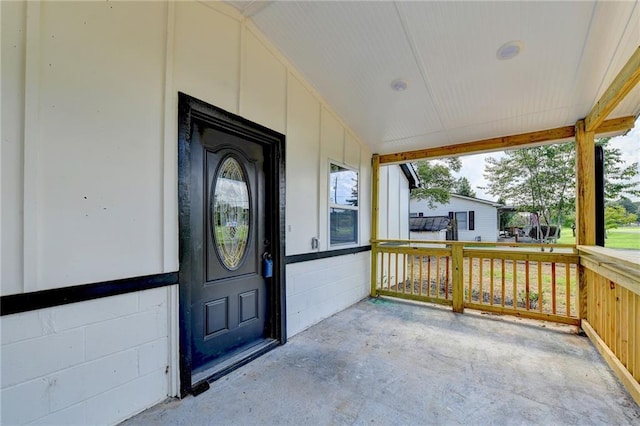 property entrance featuring covered porch and concrete block siding