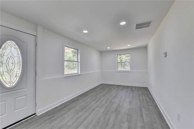 entrance foyer featuring baseboards, visible vents, and wood finished floors