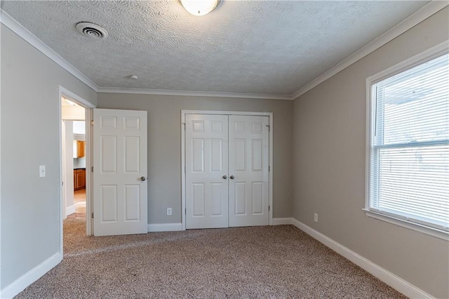 unfurnished bedroom featuring crown molding, a closet, carpet, and a textured ceiling