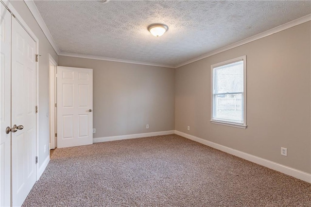 unfurnished room with ornamental molding, a textured ceiling, and carpet flooring