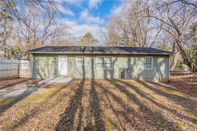 back of house with cooling unit and a yard