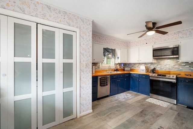 4223 Spring Valley Dr, Cohutta, GA 30710 - kitchen featuring appliances with stainless steel finishes, blue cabinetry, light wood-type flooring, butcher block countertops, and wallpapered walls