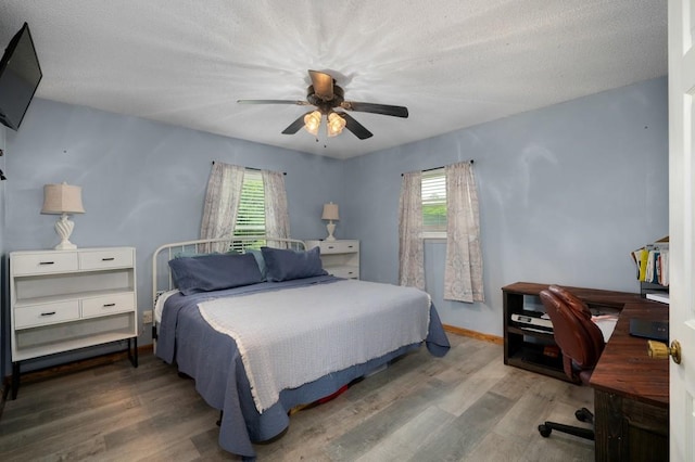 4223 Spring Valley Dr, Cohutta, GA 30710 - bedroom with multiple windows, wood finished floors, an office area, a ceiling fan, and a textured ceiling