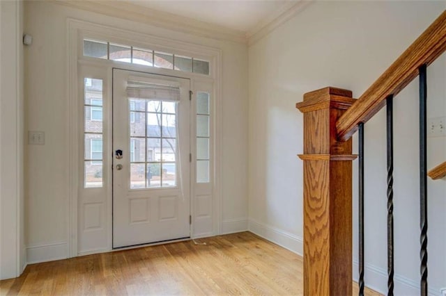 entryway with ornamental molding and light wood-type flooring