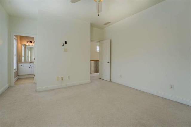 unfurnished bedroom with ensuite bathroom and light colored carpet