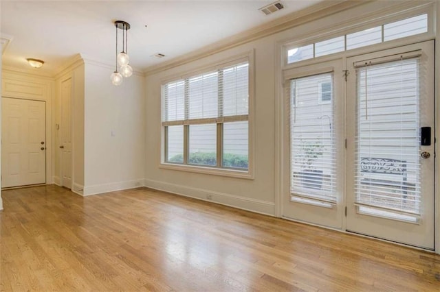 doorway to outside featuring ornamental molding and light hardwood / wood-style floors