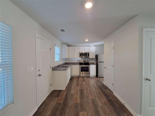 kitchen featuring white cabinetry, sink, dark hardwood / wood-style flooring, and appliances with stainless steel finishes