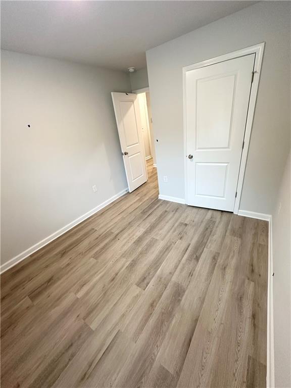 unfurnished bedroom with light hardwood / wood-style floors and a closet