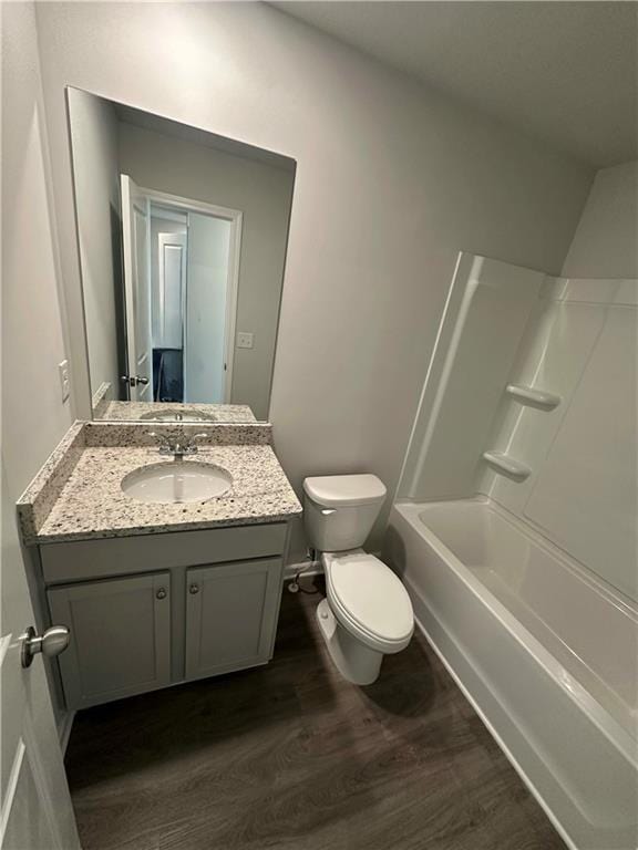 full bathroom featuring vanity, hardwood / wood-style flooring, shower / washtub combination, and toilet