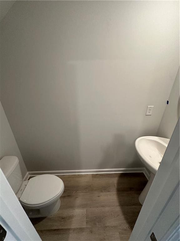 bathroom featuring wood-type flooring and toilet