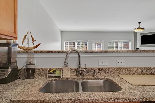 room details featuring stone countertops and a sink