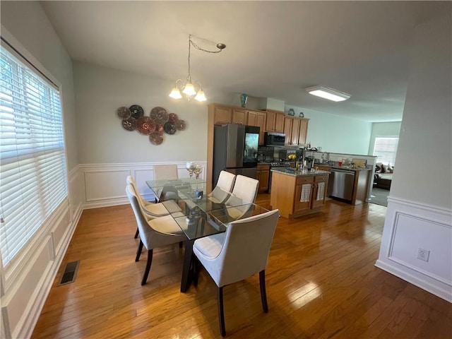 dining area with a chandelier and light hardwood / wood-style flooring