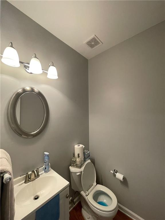 bathroom featuring vanity, toilet, and hardwood / wood-style floors