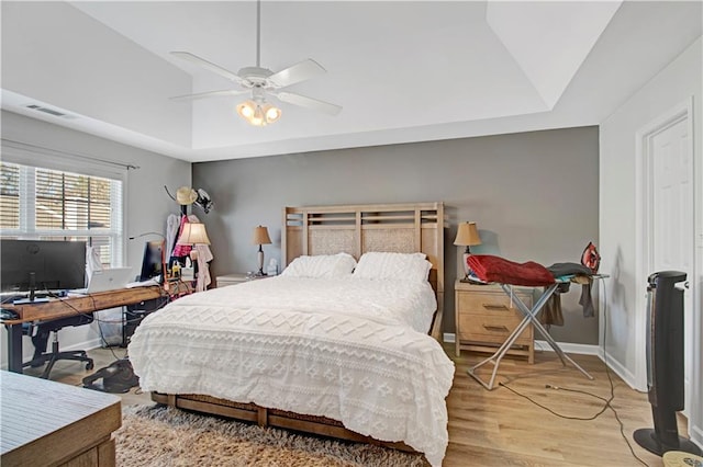 bedroom featuring baseboards, visible vents, a ceiling fan, and light wood-style floors