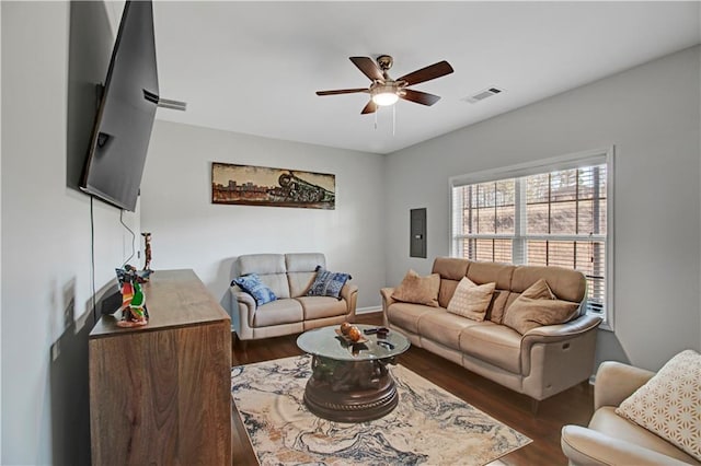 living room with ceiling fan, electric panel, visible vents, and wood finished floors