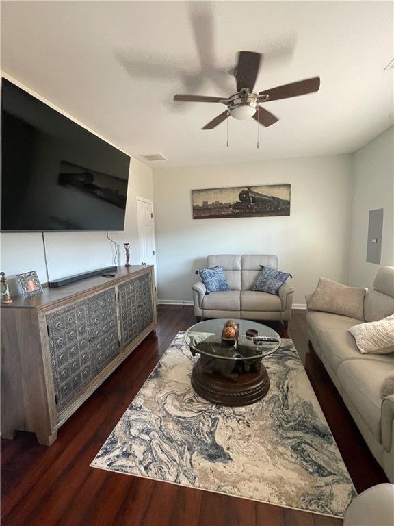 living room with ceiling fan, dark hardwood / wood-style flooring, and electric panel