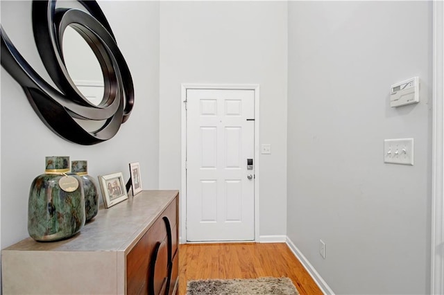 doorway to outside featuring light wood-style flooring and baseboards