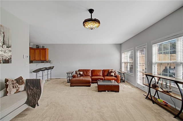 living room with baseboards and light colored carpet