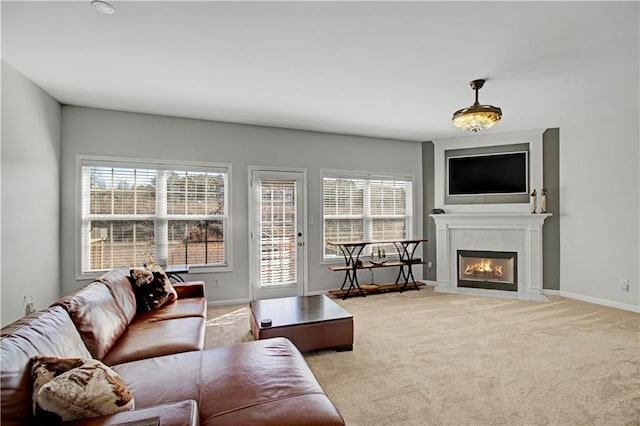 carpeted living room featuring a fireplace with flush hearth and baseboards