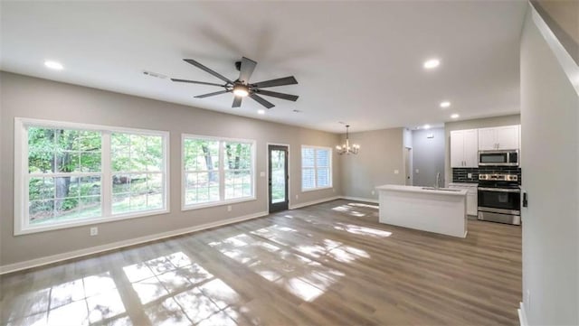 kitchen featuring decorative light fixtures, white cabinetry, backsplash, a center island, and stainless steel appliances