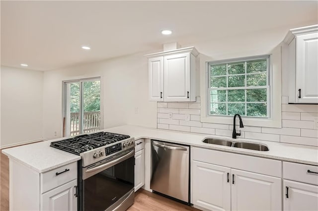 kitchen featuring white cabinets, sink, kitchen peninsula, and stainless steel appliances