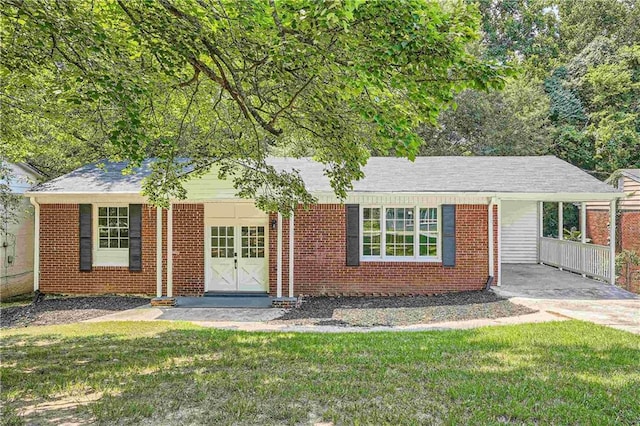 ranch-style house with a front lawn, a porch, and a carport