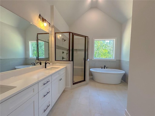 bathroom with tile patterned flooring, vanity, lofted ceiling, and independent shower and bath