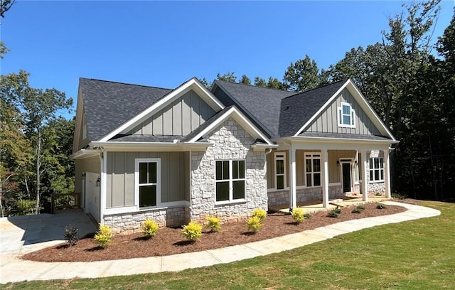 craftsman-style house featuring a carport, covered porch, and a front lawn