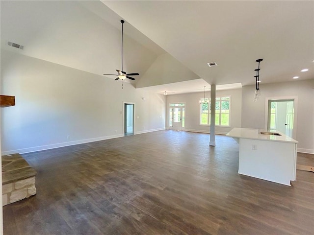 unfurnished living room with vaulted ceiling, ceiling fan, and dark wood-type flooring