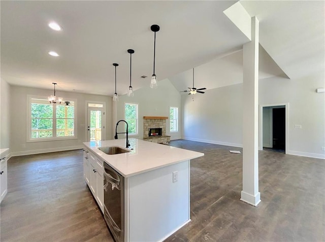 kitchen with white cabinets, a kitchen island with sink, sink, dishwasher, and hanging light fixtures