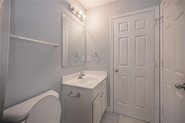 bathroom with tile patterned flooring, vanity, and toilet