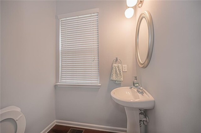 bathroom with wood-type flooring and toilet