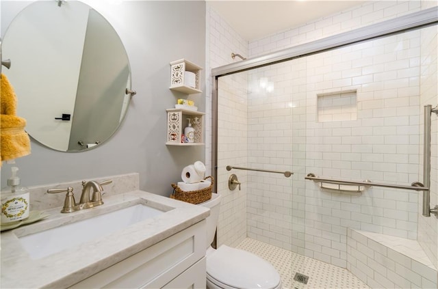 full bathroom with toilet, vanity, and a stall shower