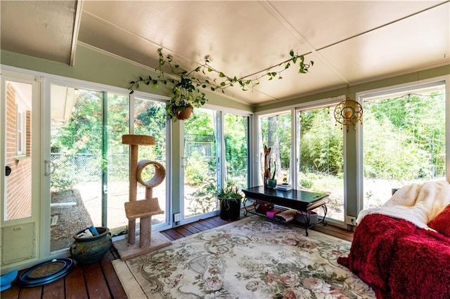 sunroom / solarium featuring lofted ceiling and hardwood / wood-style floors